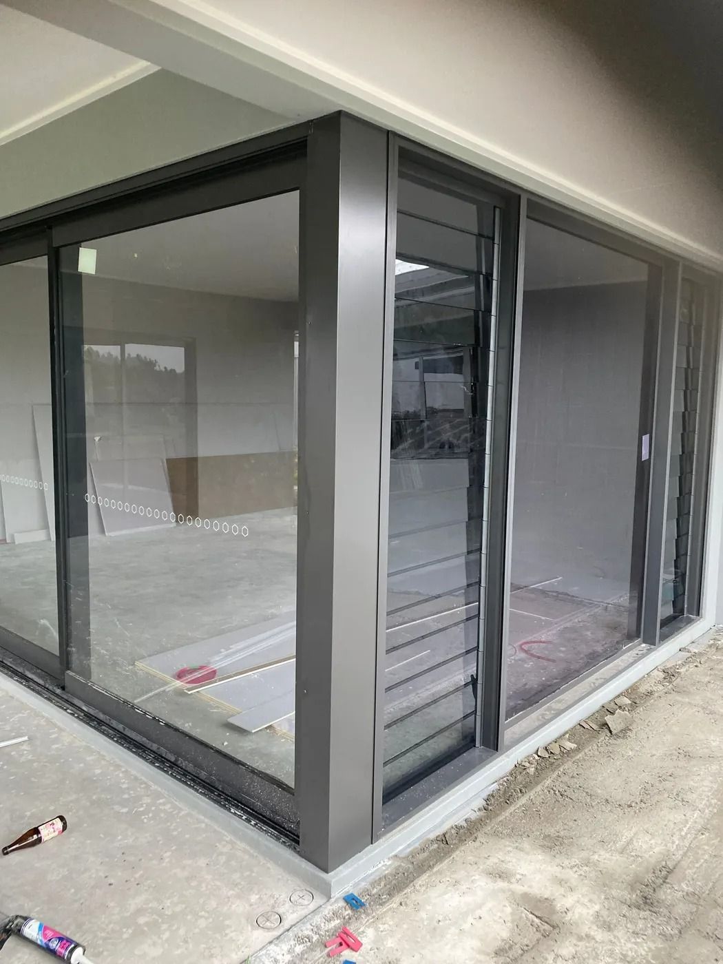 Corner of a Building With Dark Gray Framed Glass Sliding Door — Innisfail Glass & Aluminium in Innisfail, QLD
