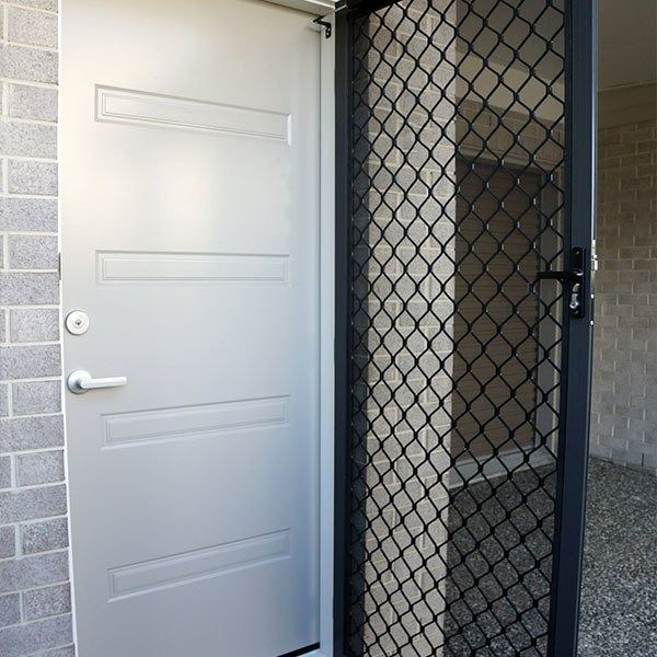 Gray Door With Security Screen, Next to a Brick Wall — Innisfail Glass & Aluminium in Innisfail, QLD