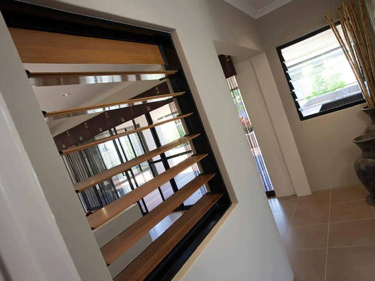 Louvered Windows and a Small Window Frame an Interior Hallway — Innisfail Glass & Aluminium in Innisfail, QLD