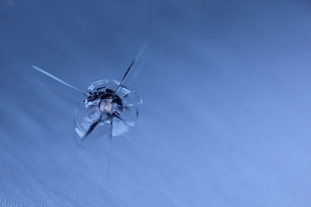 Shattered Glass With Radial Cracks Against a Blue Backdrop — Innisfail Glass & Aluminium in Tully, QLD
