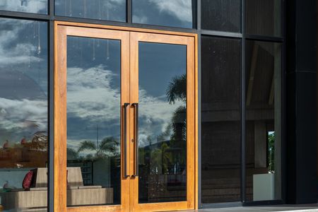 A building with a wooden door and a lot of windows.