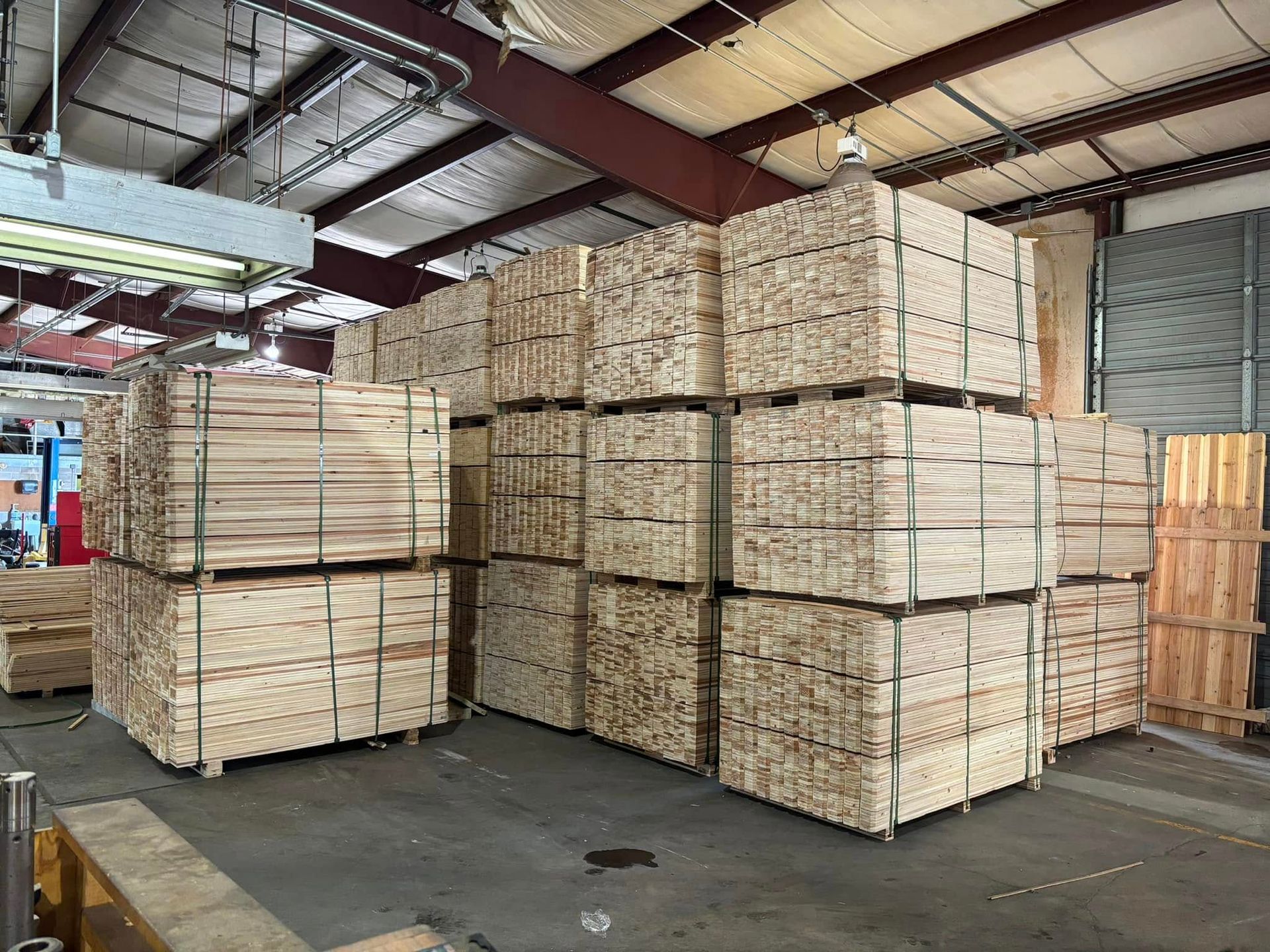 A warehouse filled with lots of wooden pallets stacked on top of each other.