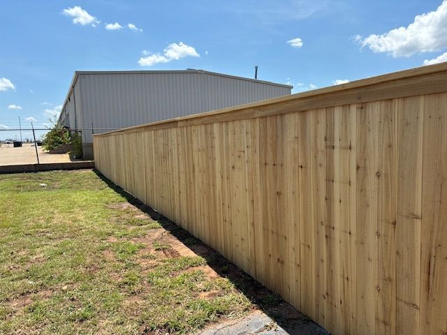 A white fence adorned with flowers, showcasing Synergy Fencing & Materials, a fence supply contracto