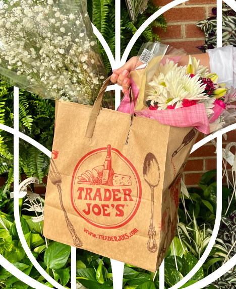 Trader Joe’s paper bag filled with flowers, including pink and white bouquets, against a garden backdrop near Prelude at Medley.