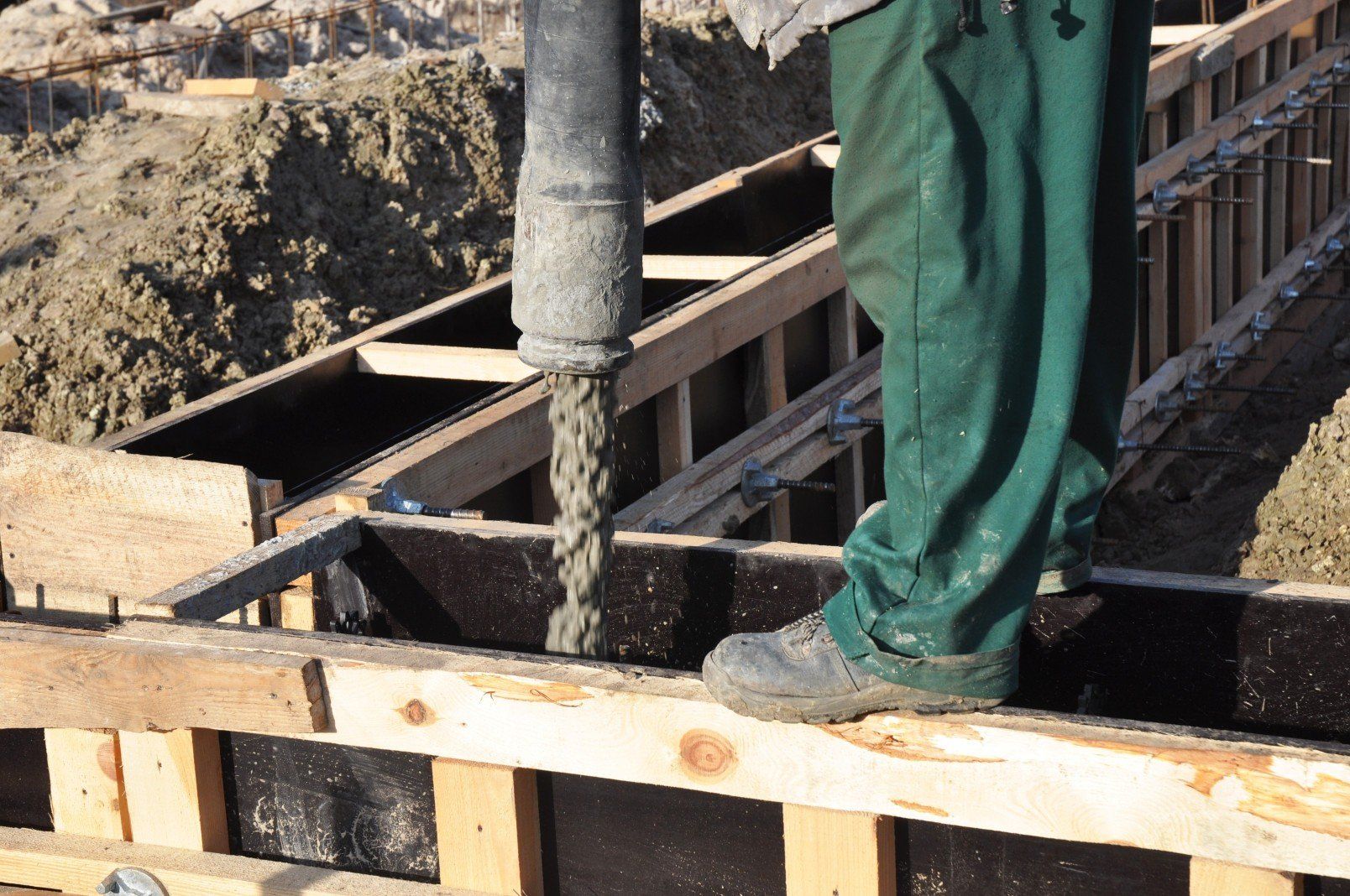 Concrete retaining wall being poured and spread by concrete finisher crew in Mandurah Concreters