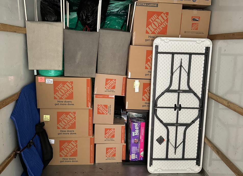 Boxes and furniture loaded inside a moving truck, ready for transport.