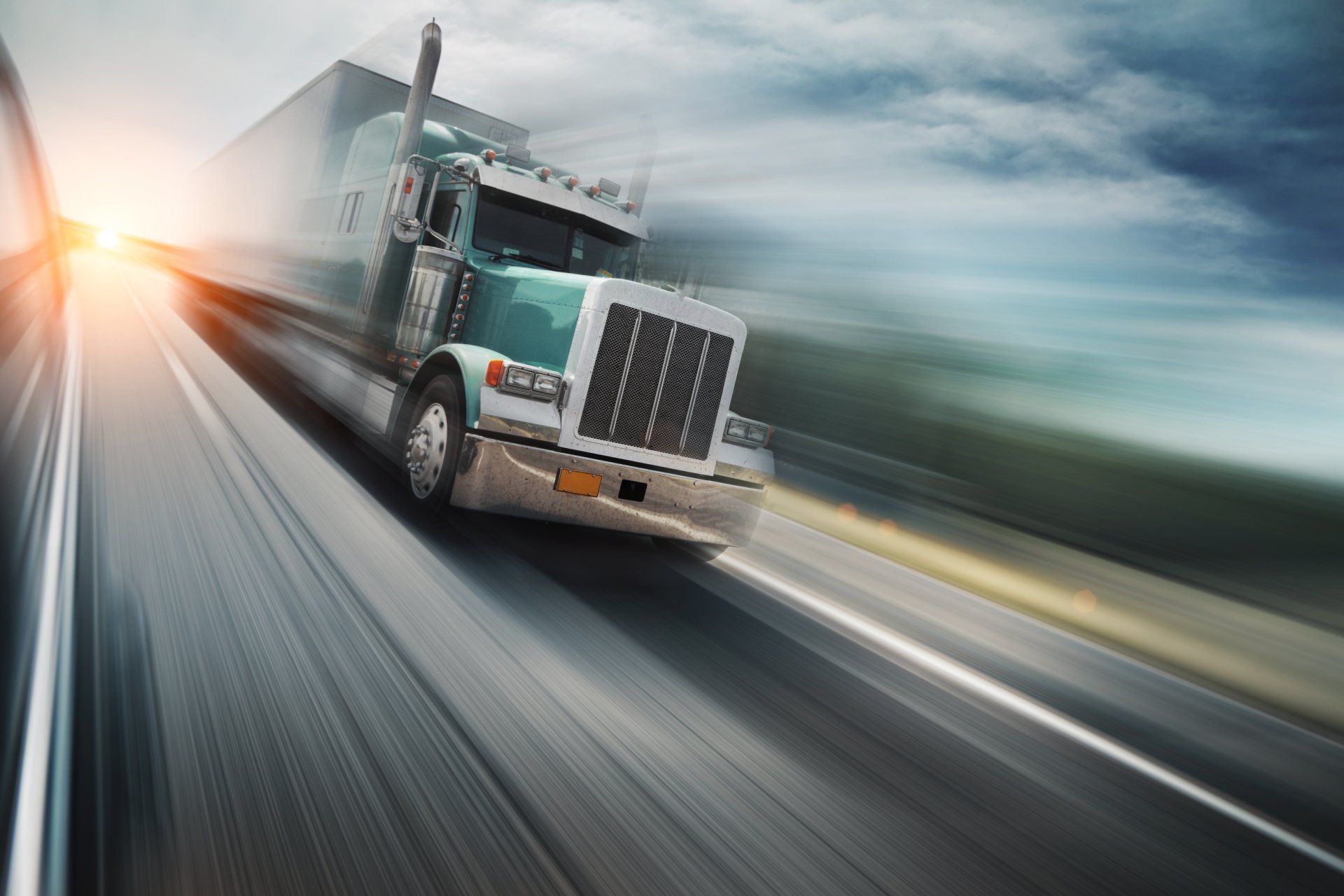A photo of a semi-truck driving fast on the highway. A photo of a semi-truck driving fast on the highway.