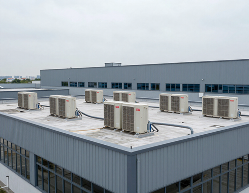 Rooftop HVAC units on a gray industrial building under an overcast sky