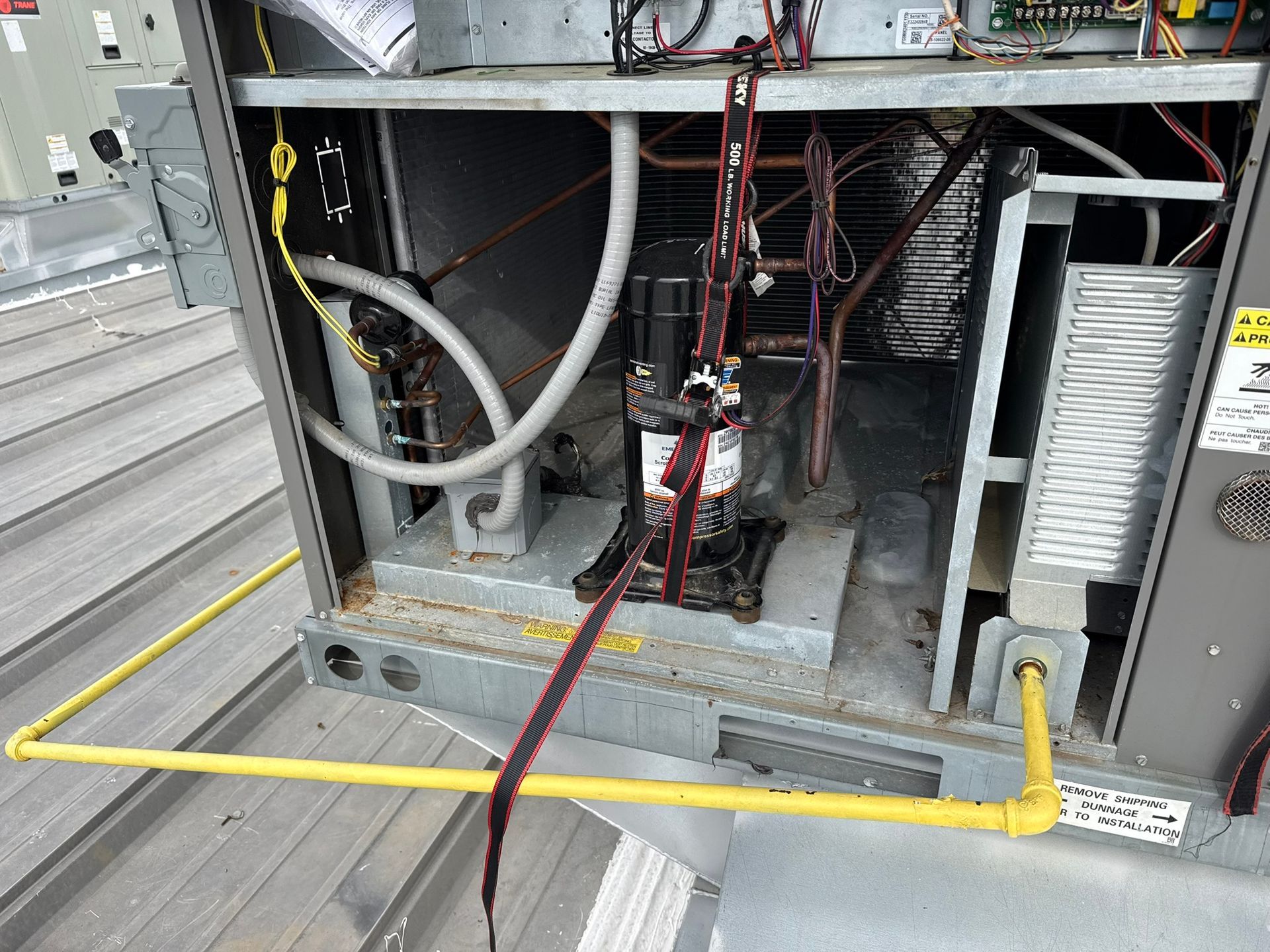 Open utility cabinet with pipes, wires, and a yellow gas line inside a metal enclosure