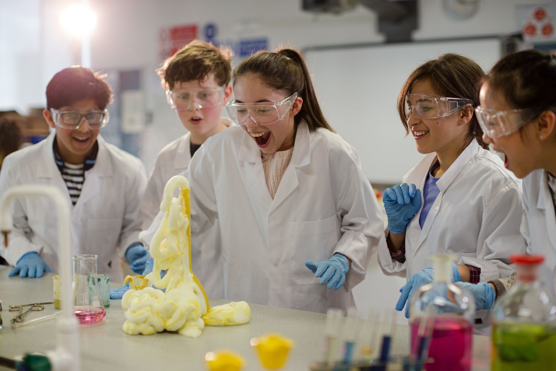 A group of children are playing with foam in a lab.