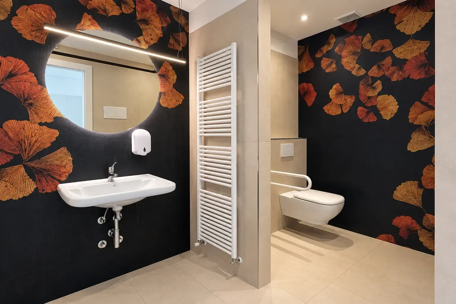 Bagno moderno con carta da parati floreale nera, lavabo bianco, specchio, termoarredo e WC in una nicchia adiacente