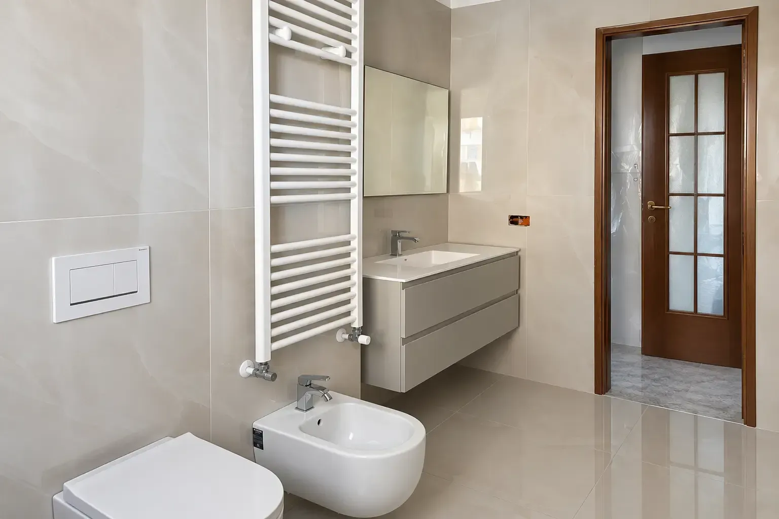 Bagno moderno piastrellato con bidet, WC, mobile lavabo, scaldasalviette e porta in legno
