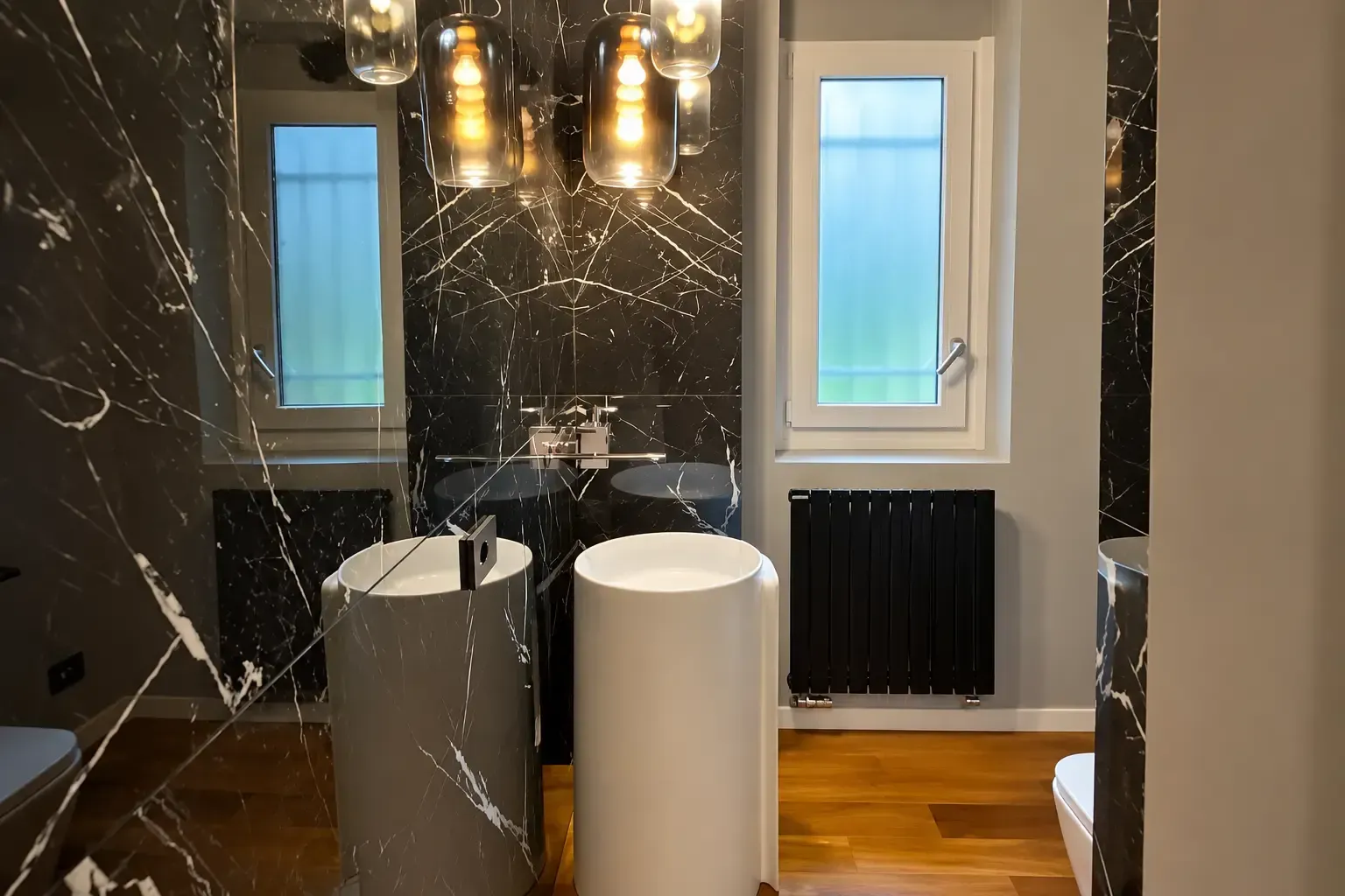 Bagno moderno con pareti in marmo nero, doppio lavabo, luci a sospensione e due finestre