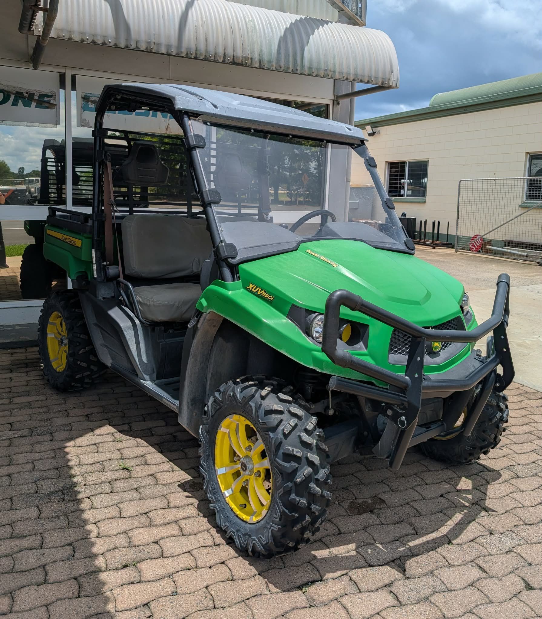 Green Utility Off-road Vehicle With Yellow Wheels Parked Outside a Building Under a Canopy — Casali's in Mareeba, QLD
