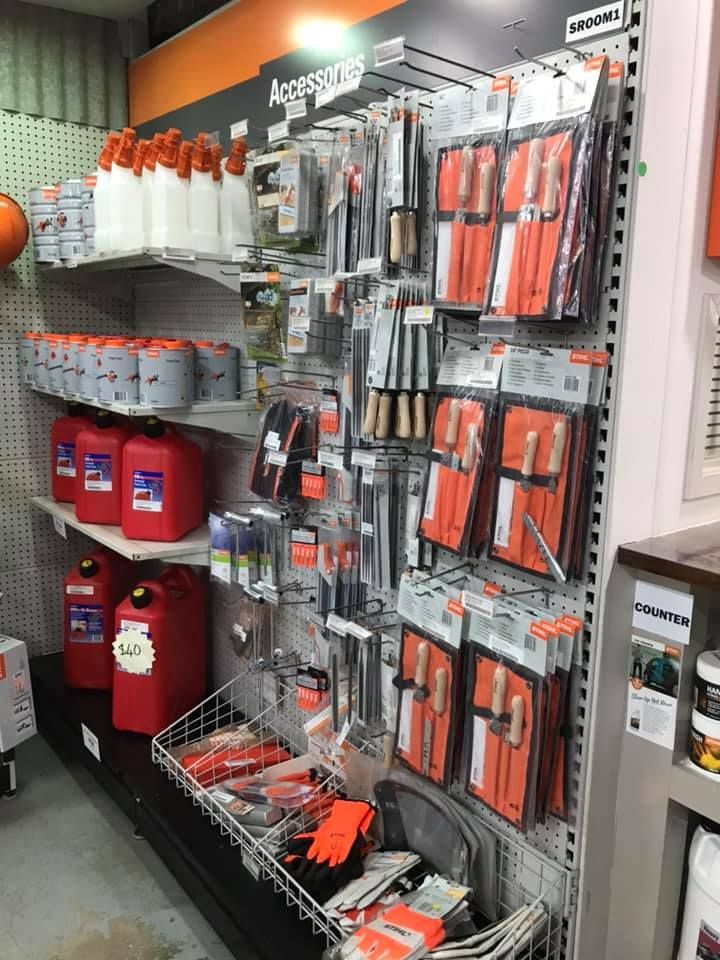Store Aisle Display of Orange and Silver Hand Tools on Pegboards With Red Paint Cans Below — Casali's in Mareeba, QLD