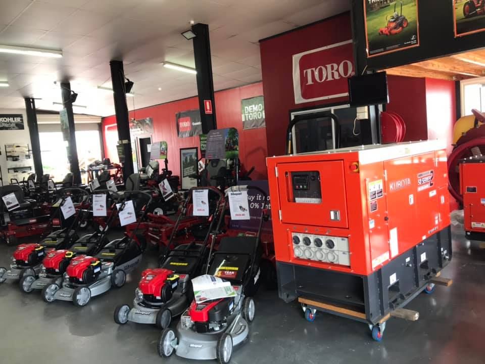 Lawn Mower Showroom With Rows of Red and Black Riding Mowers and a Large Orange Generator Display — Casali's in Mareeba, QLD
