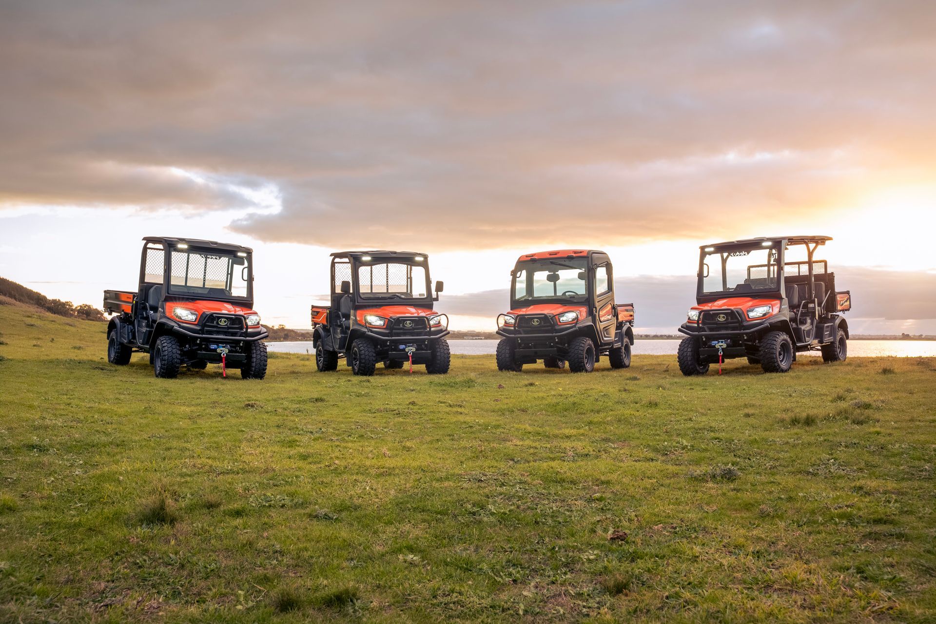 Four utility vehicles parked on a grassy field under a cloudy sky — Casali's in Mareeba, QLD