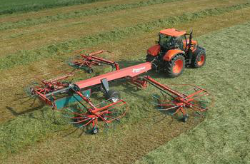 Orange Tractor Towing a Red Hay Rake Across a Grassy Field — Casali's in Mareeba, QLD