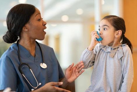 Nurse assisting child with inhaler