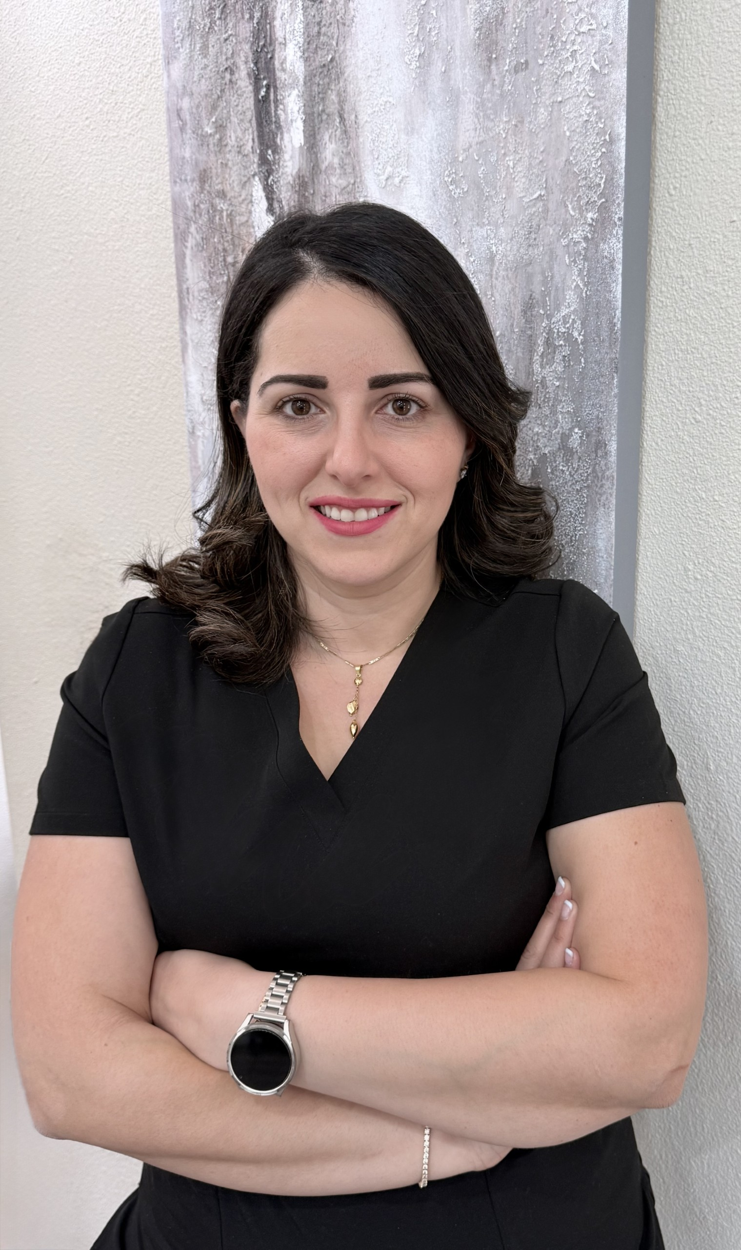 Dental Hygienist wearing a black shirt with her arms crossed.