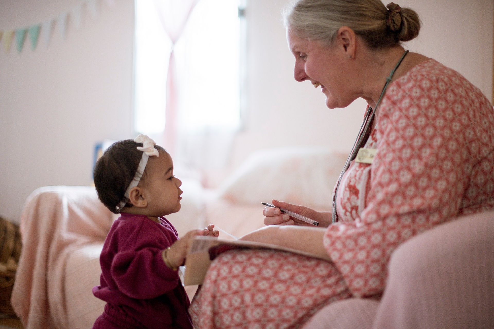 Playgroup leader and toddler enjoying a quiet moment of shared delight in a Steiner classroom