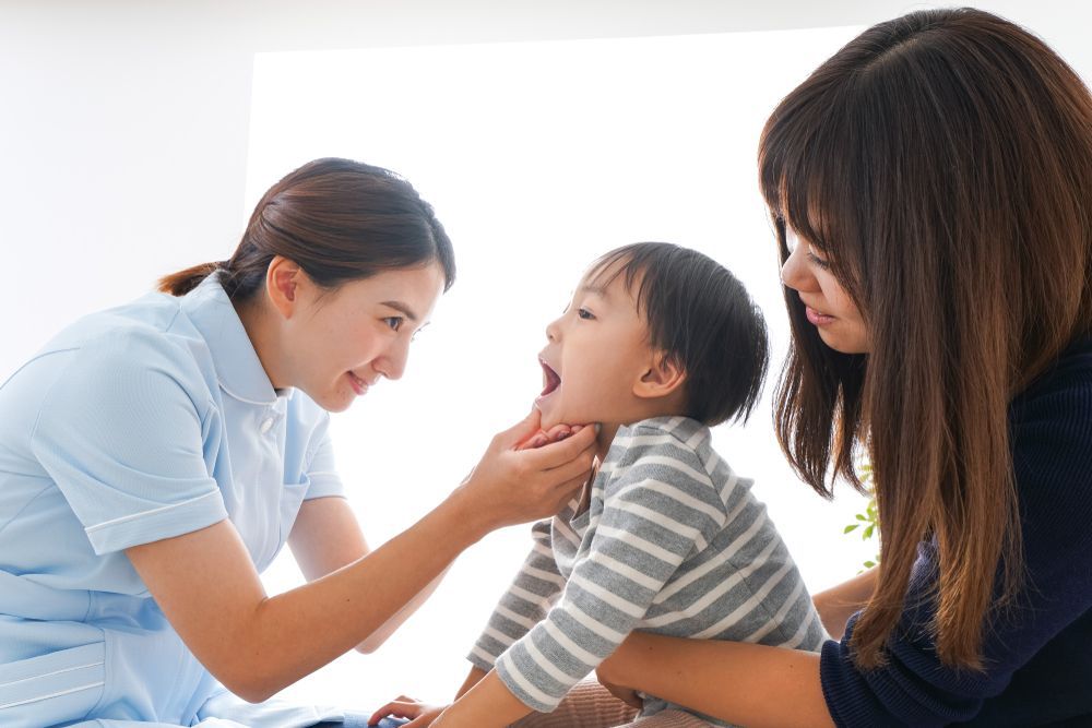 Nurse Inspecting a Child's Mouth While Accompanied by a Parent