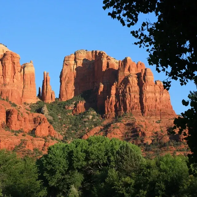 Sedona mountain with trees in the foreground and clear blue sky near Southwest Inn Sedona