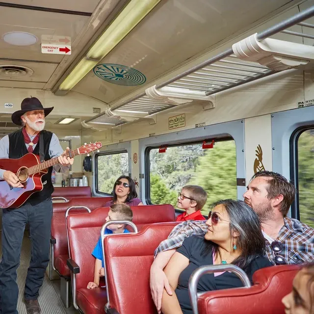 Man singing and playing guitar during scenic train ride near Sedona and Southwest Inn Sedona