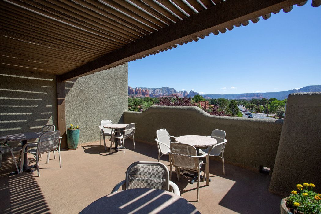 Patio at Southwest Inn Sedona with tables, chairs, and scenic mountain views