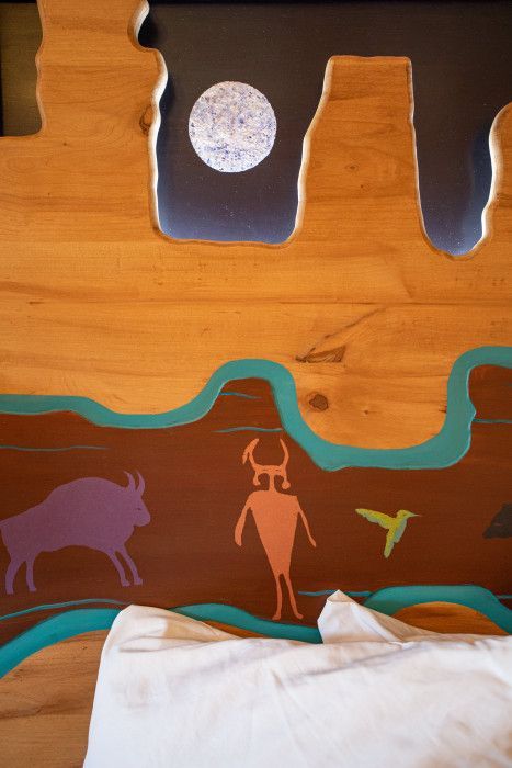 Wooden table with a painting of a man and bird, adding artistic charm at Southwest Inn Sedona