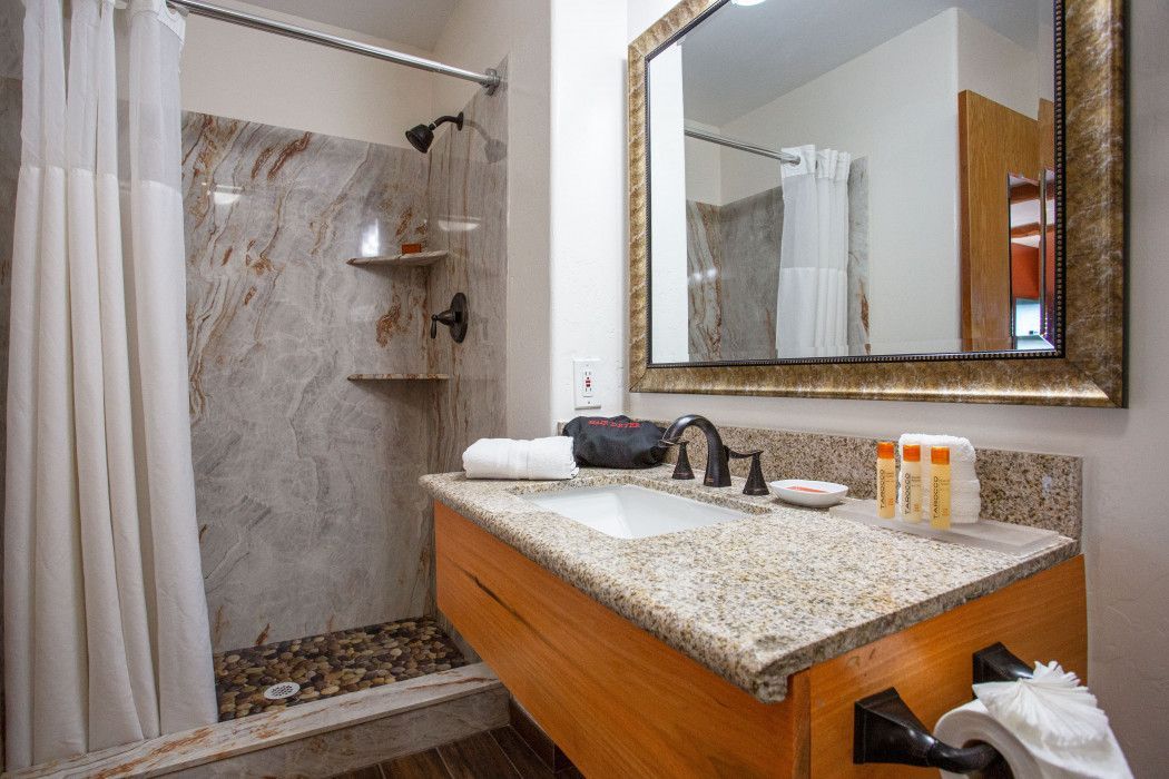 Bathroom at Southwest Inn Sedona with sink, mirror, and walk-in shower