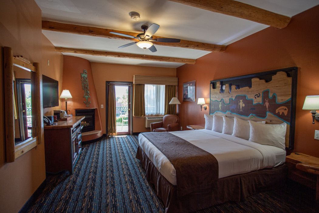 Hotel room at Southwest Inn Sedona with king-size bed and cozy fireplace