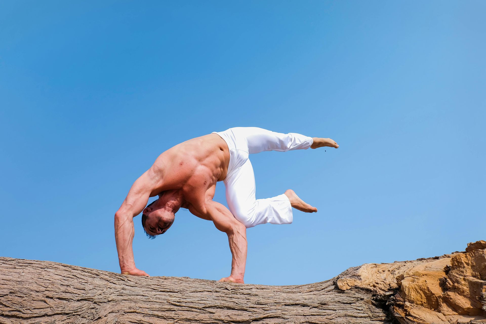 Man doing a handstand on red rock formation in Sedona near Southwest Inn Sedona