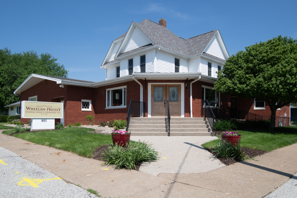 Brick building with a white upper story and a sign that reads