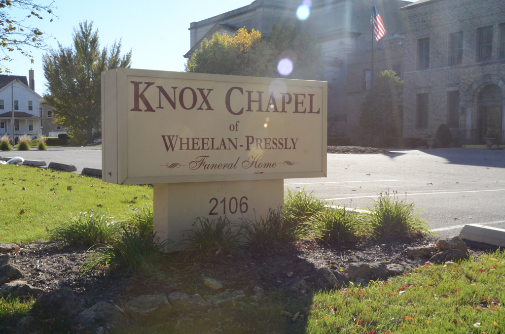 Sign for Knox Chapel of Whelan Pressley Funeral Home, 2106, with building in background.