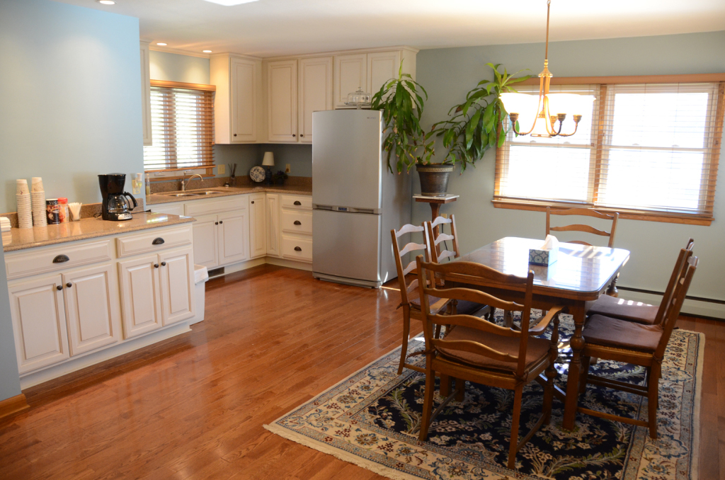 Kitchen and dining area with light cabinets, wood floors, and a table with chairs.