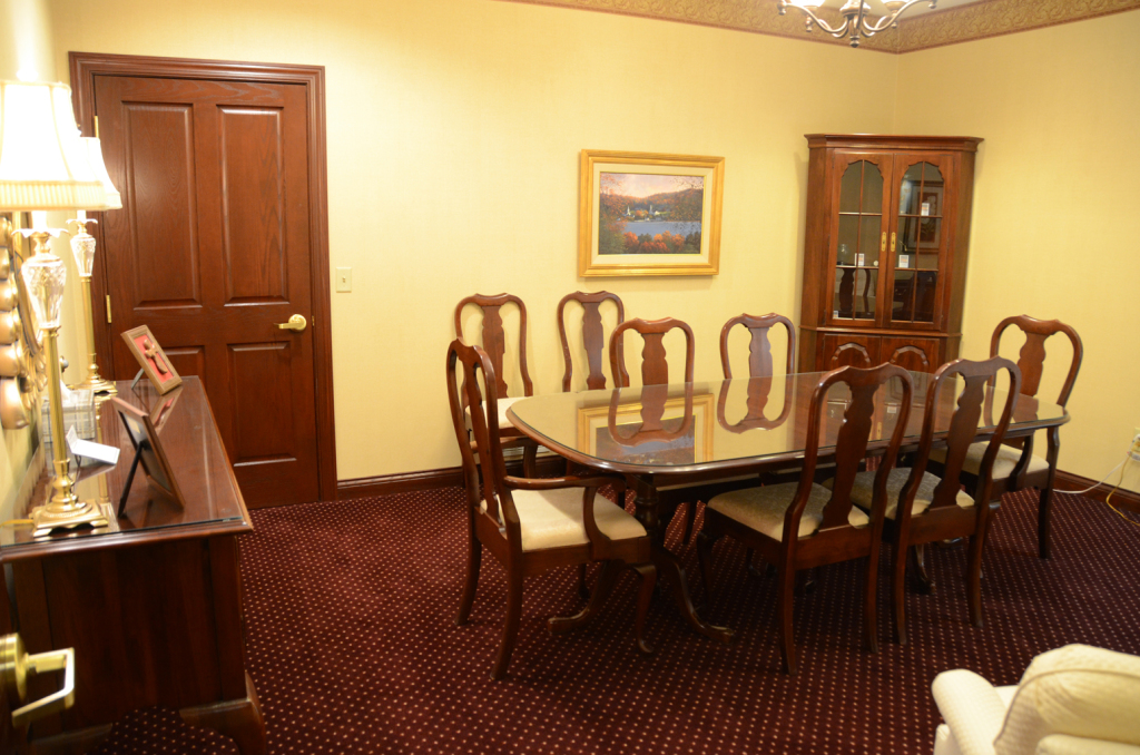 Formal dining room with wood furniture, eight chairs around a table, and a cabinet.