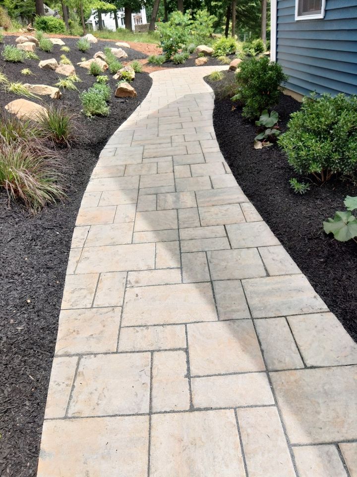 A walkway leading to a house with a blue house in the background