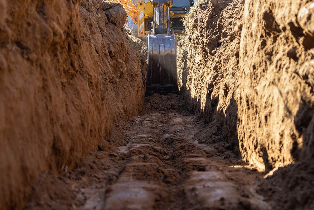 A bulldozer is digging a trench in the ground.