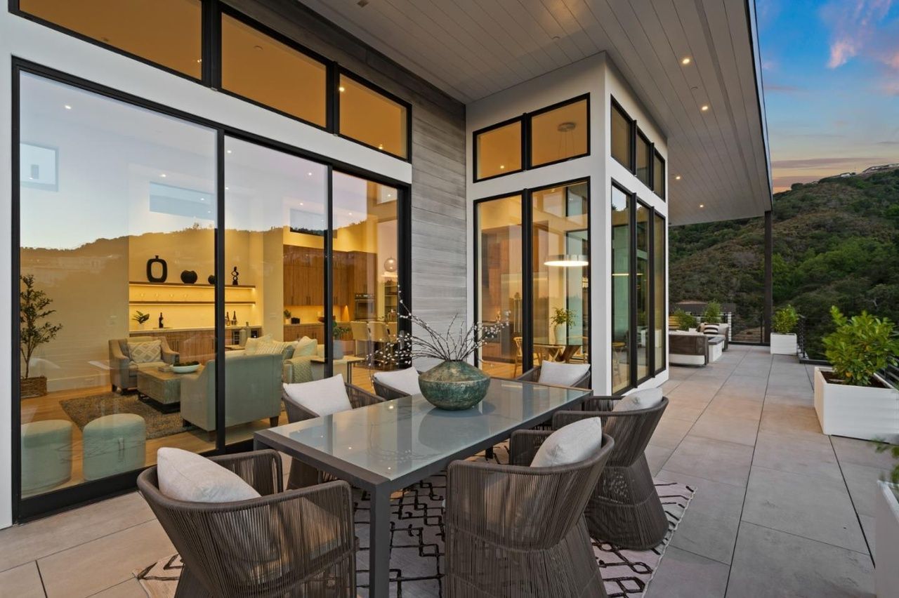 There is a table and chairs on the patio of a house.