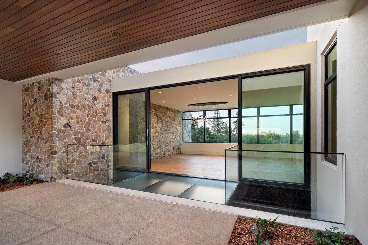 A house with a lot of windows and sliding glass doors