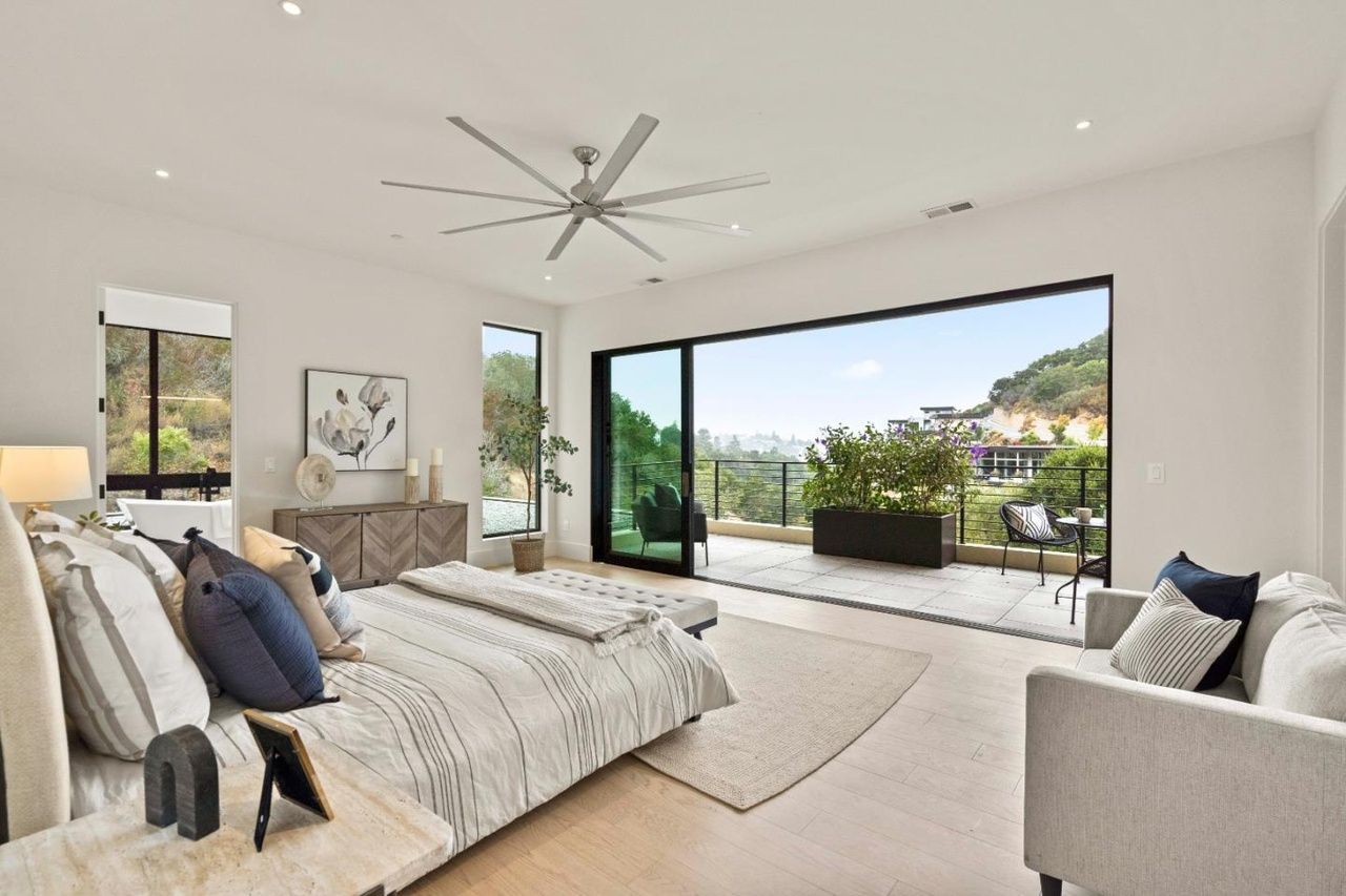 A bedroom with a large bed and a ceiling fan.