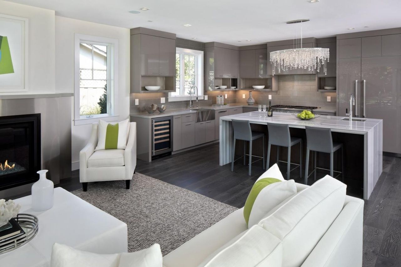 A living room filled with furniture and a kitchen with a fireplace