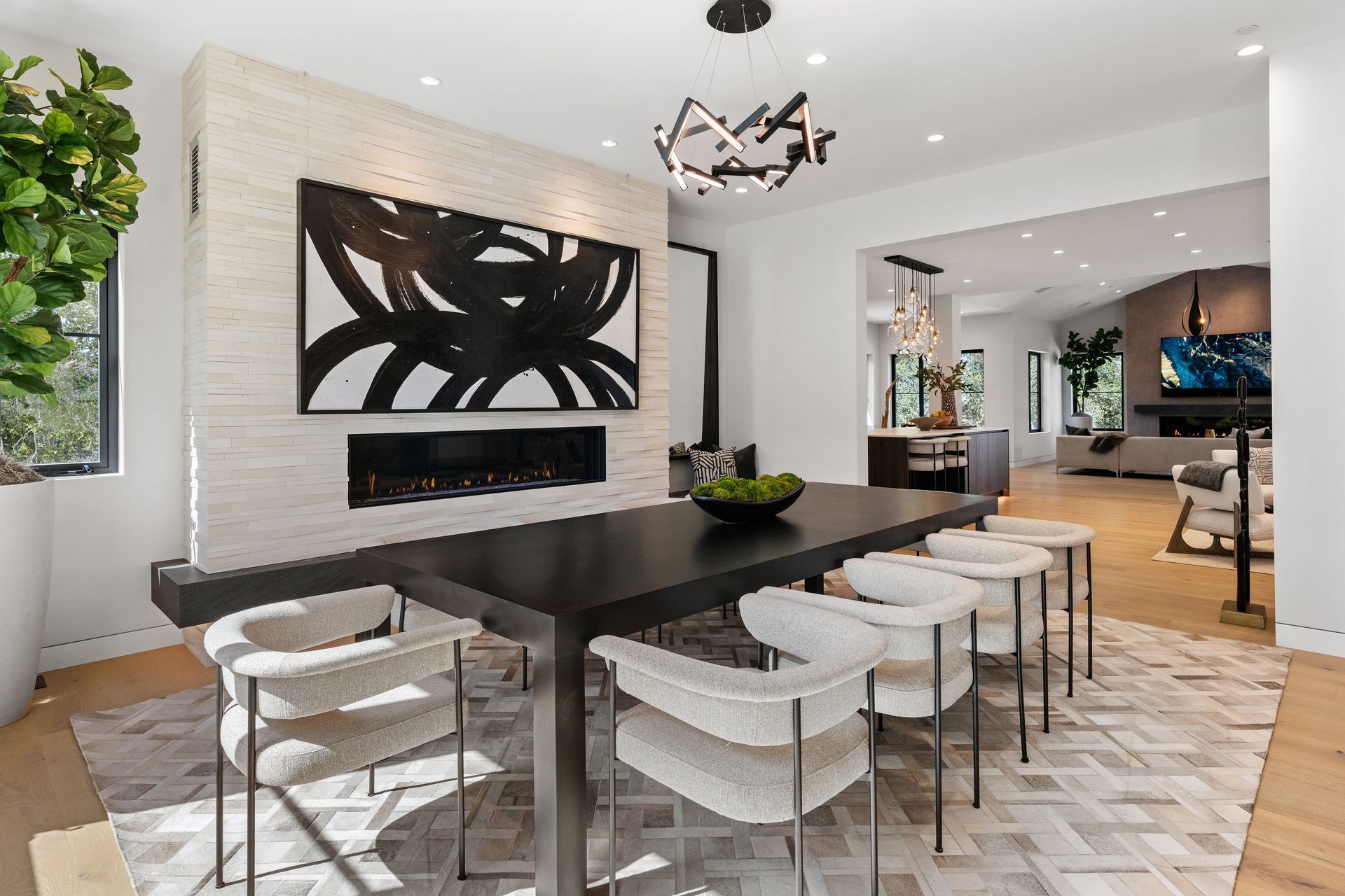 A dining room with a table and chairs and a fireplace.
