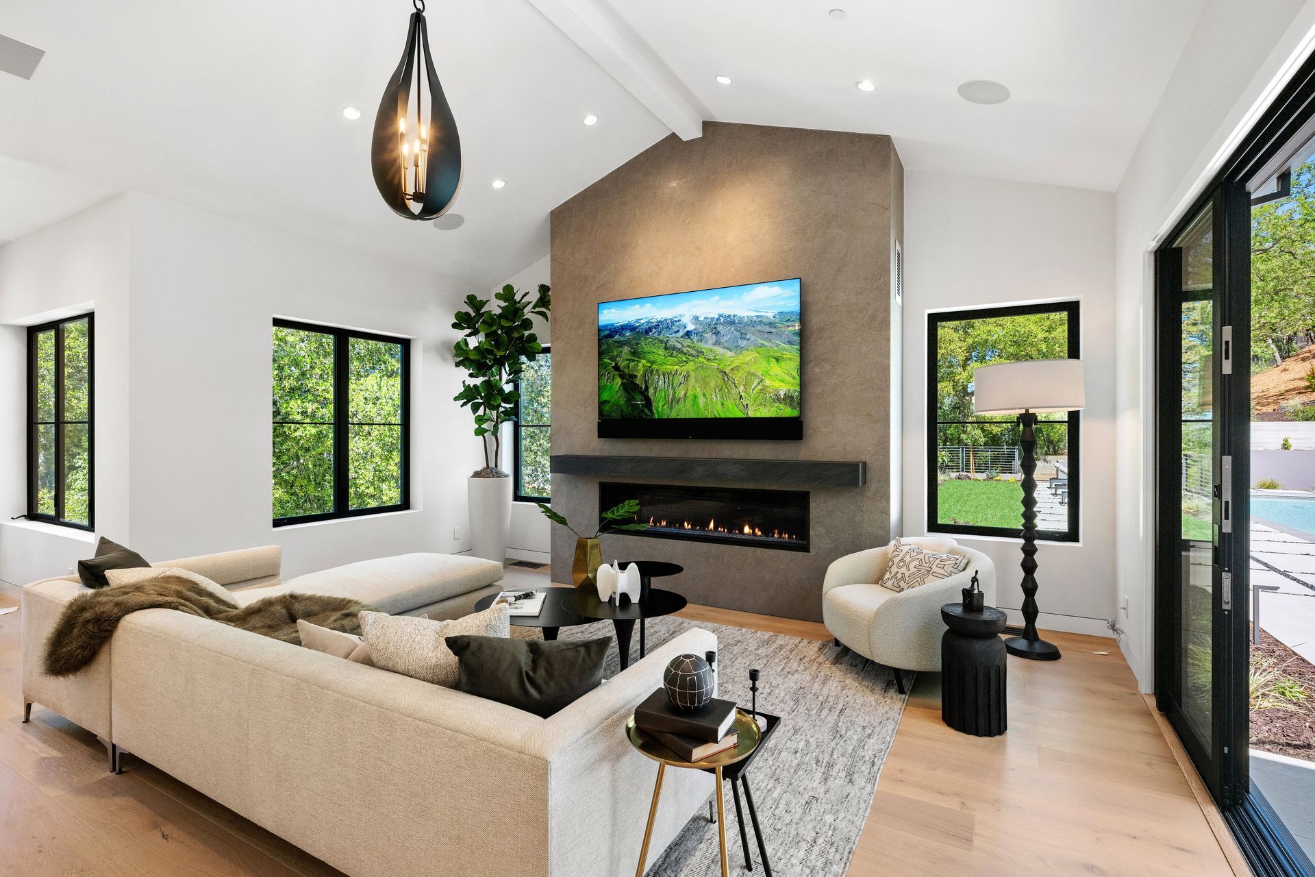 A living room with a couch , chair , television and fireplace.