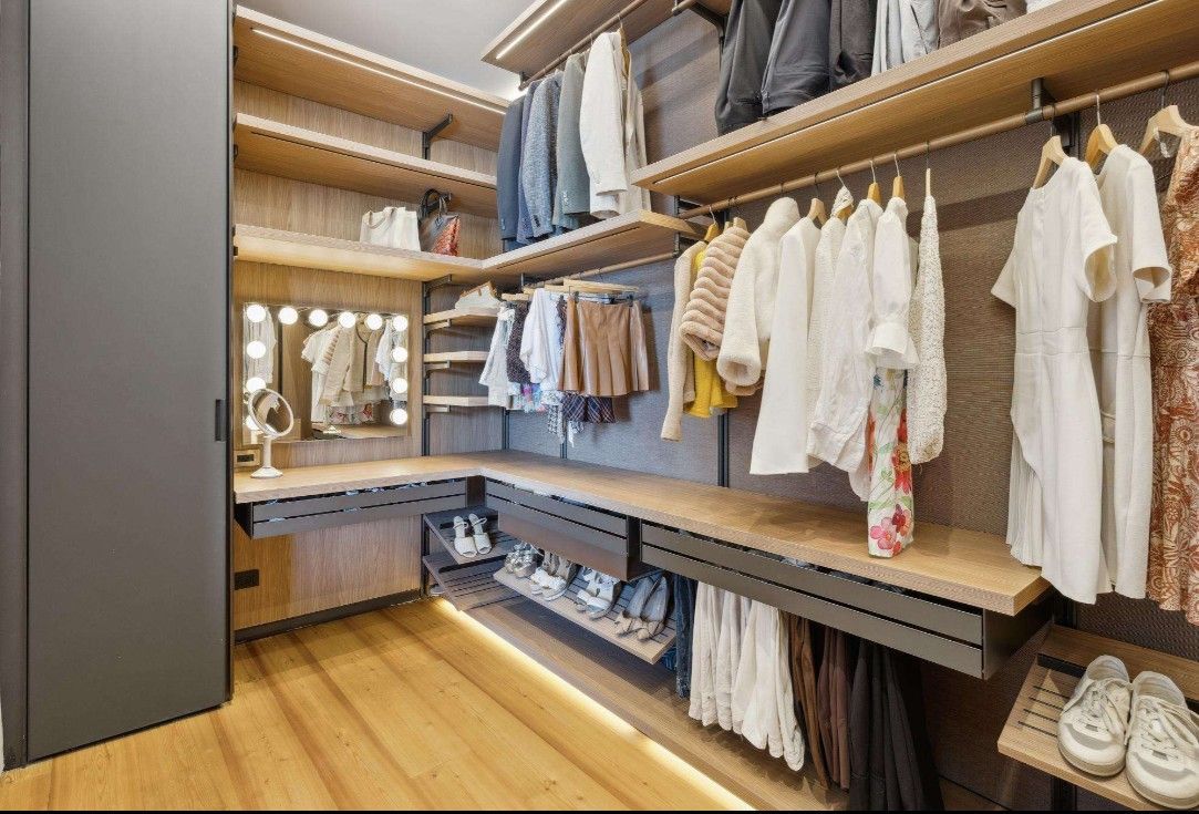 A walk in closet filled with lots of clothes and shoes.