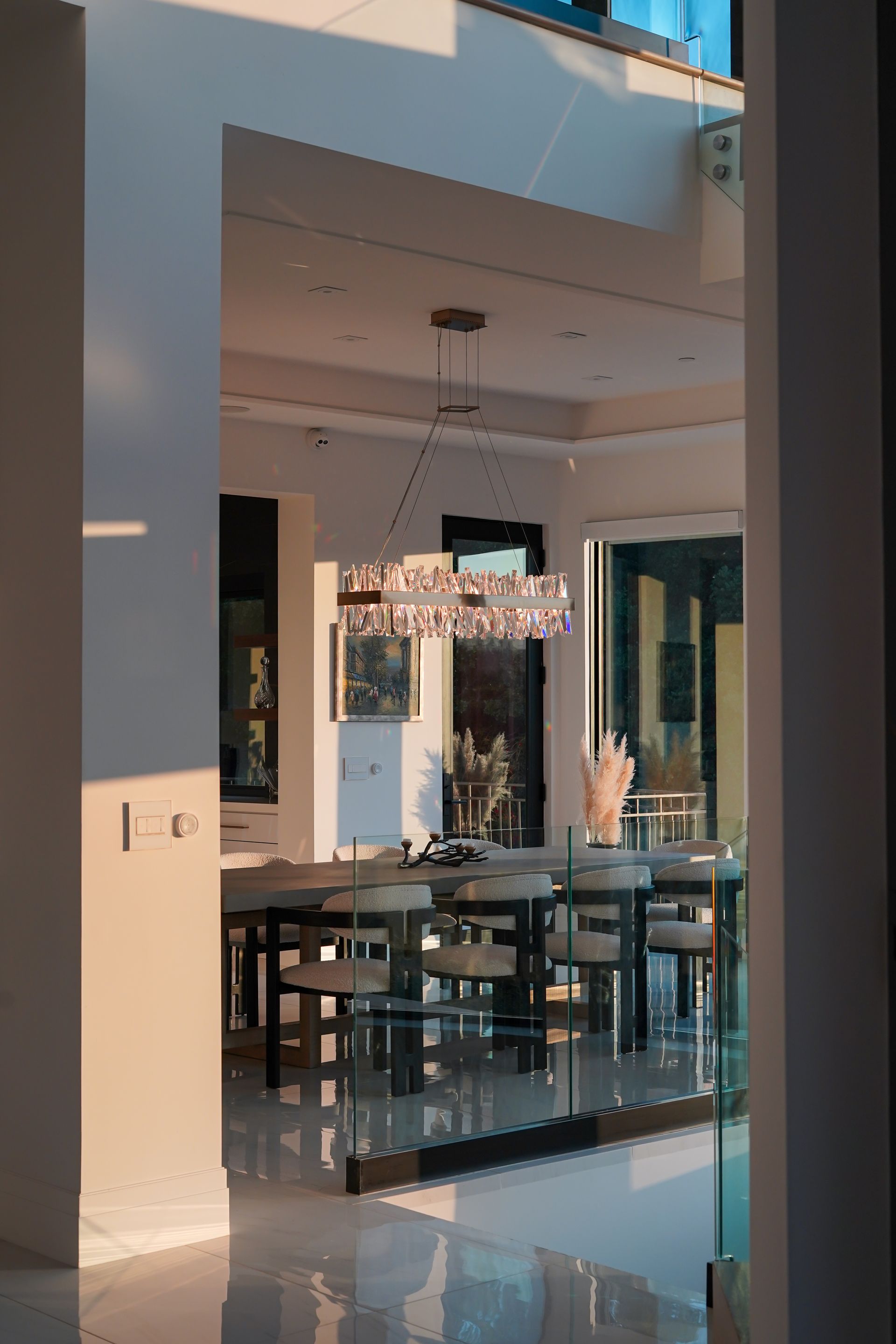 A dining room with a table and chairs and a chandelier hanging from the ceiling.