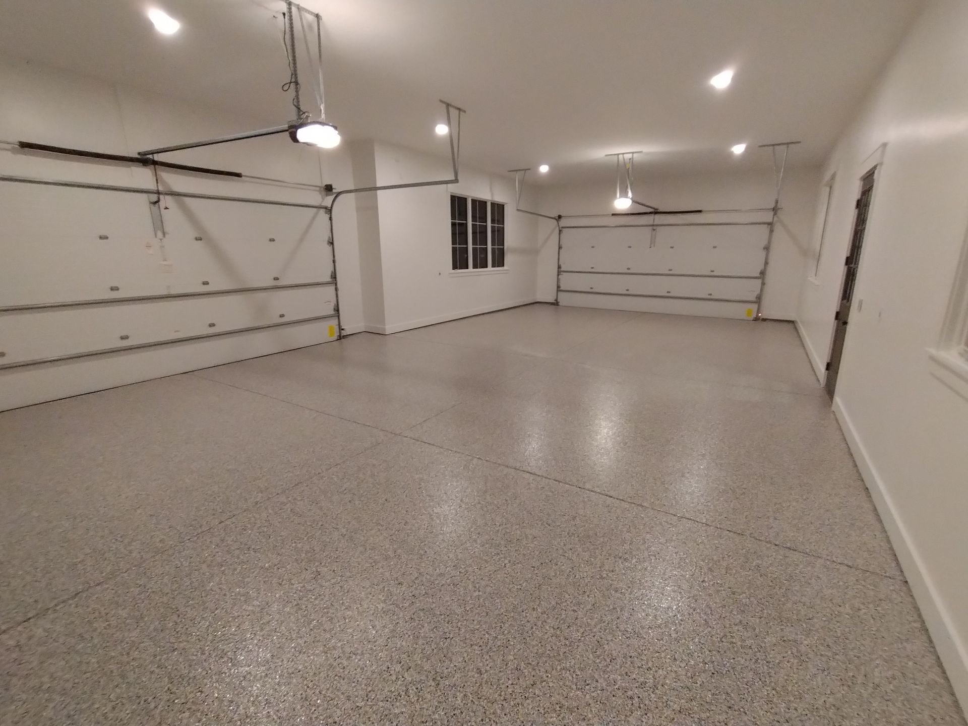 Empty, freshly painted garage with a speckled floor.