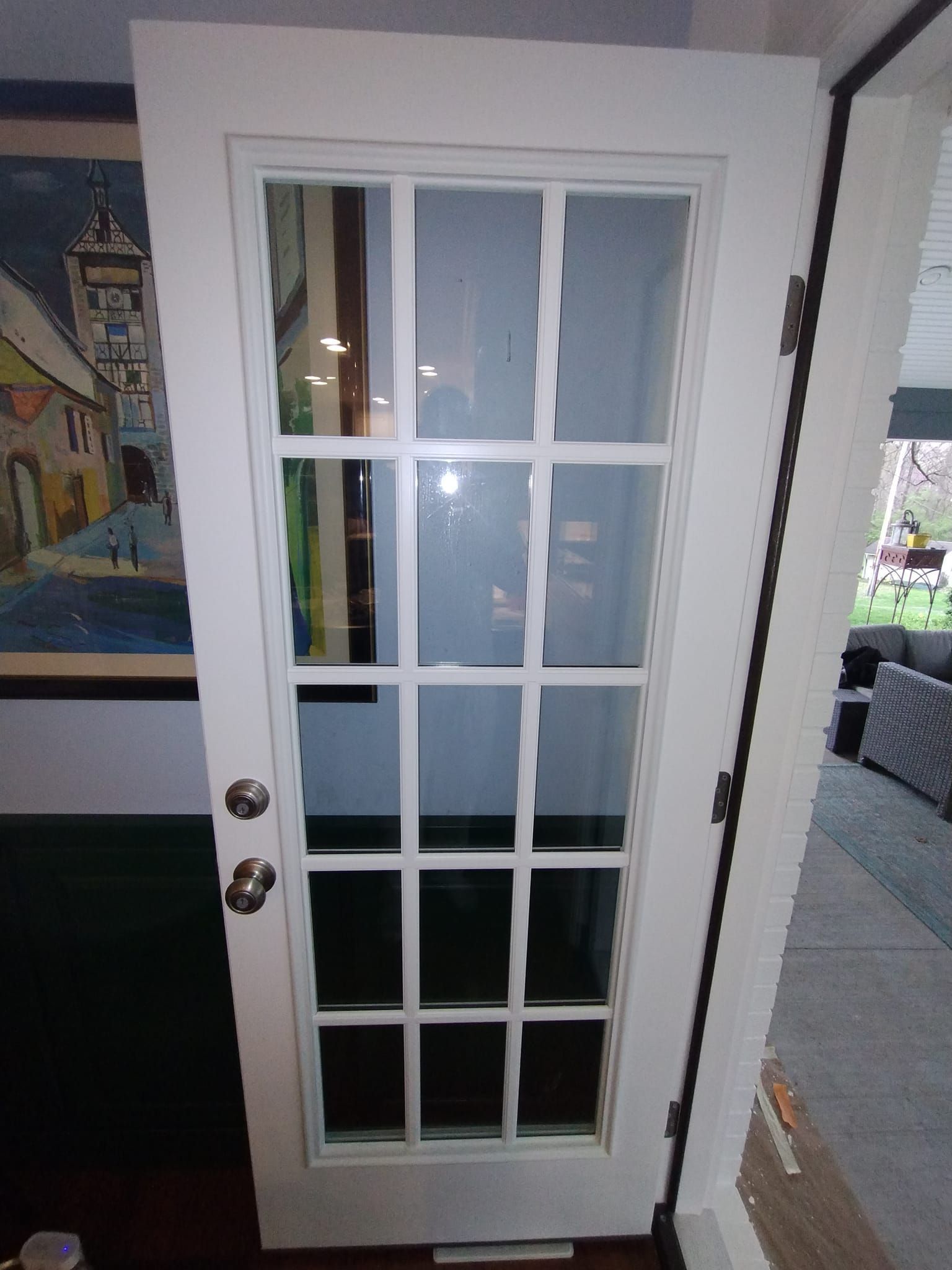 A white door with a picture on the wall behind it