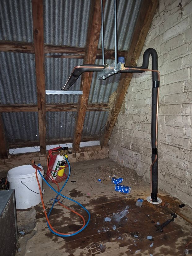 Technician connecting refrigerant lines on an outdoor compressor unit